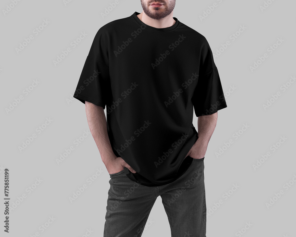 Mockup of a black oversized t-shirt on a man with his hands in pockets in dark jeans, front view, for design, branding. Mockup of a black oversized t-shirt on a man with his hands in pockets in dark jeans, front view, for design, branding.