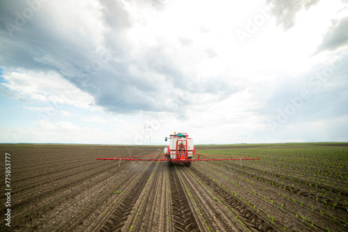 Tractor spraying pesticides at corn fields