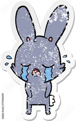 distressed sticker of a cute cartoon rabbit crying