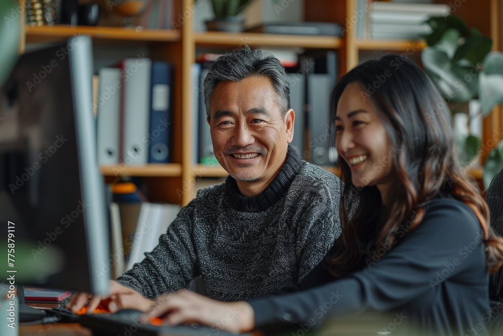 An Asian daughter imparts computer knowledge to her father, illustrating a heartwarming scene of familial bonding and technological education.