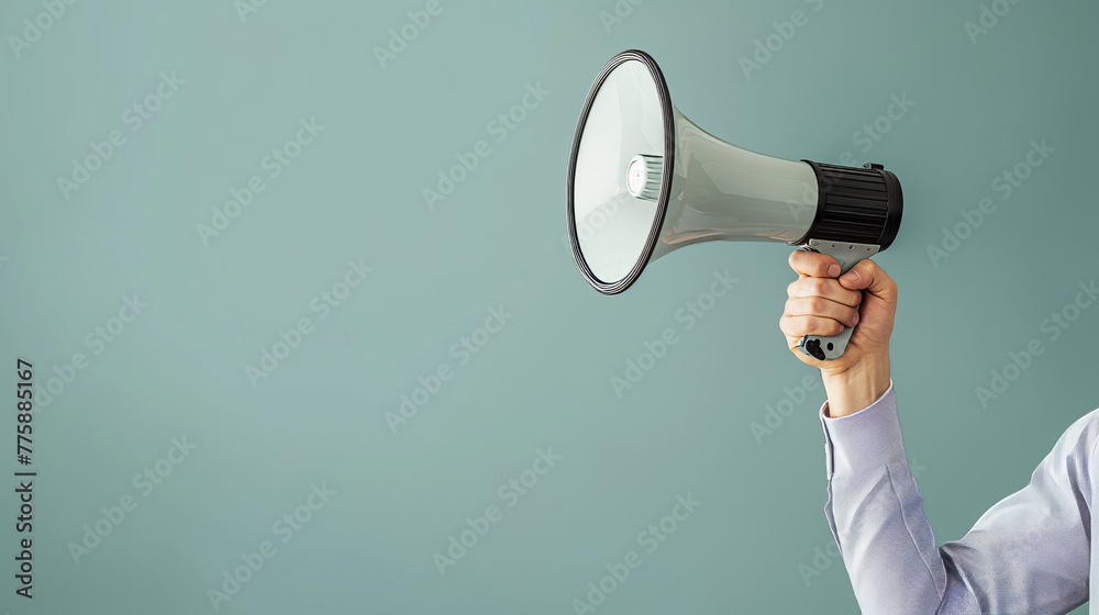 Two-tone image capturing an arm in a casual plaid sleeve holding a megaphone against a neutral gray background, symbolizing announcement Two-tone image capturing an arm in a casual plaid sleeve holding a megaphone against a neutral gray background, symbolizing announcement