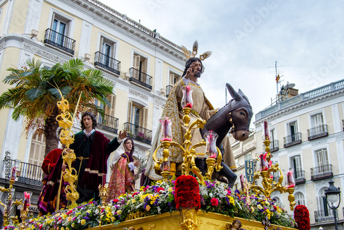 holy week sculpture with Jesus in a donkey and other images in a procession in a  stree in Madrid. 