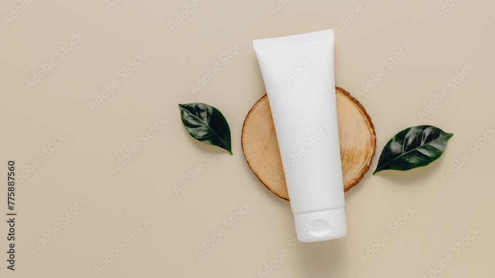 Φωτογραφία Unbranded mockup facial cream tube on wooden podium with green leaves top view, copy space