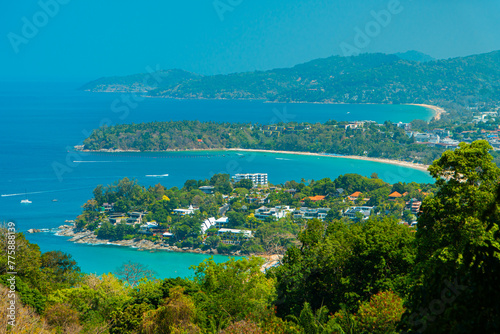Viewpoint of Karon Beach  Kata Beach and Kata Noi in Phuket  Thailand. The beautiful coastal basin and surrounding buildings are visible from a distance and the sky is blue from a high vantage point.