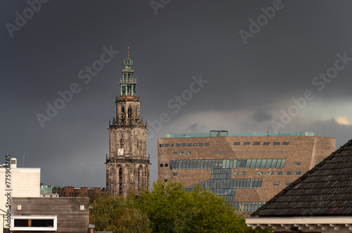 The Martinitoren and the Forum building under a dark sky in the historical city centre of Groningen.