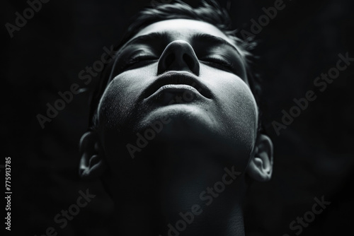 A creative and artistic photo of a person's face with their eyes closed and their head tilted back