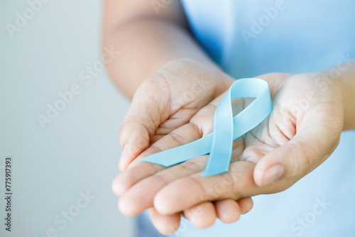 woman with blue ribbon for patients with breast and cervical cancer