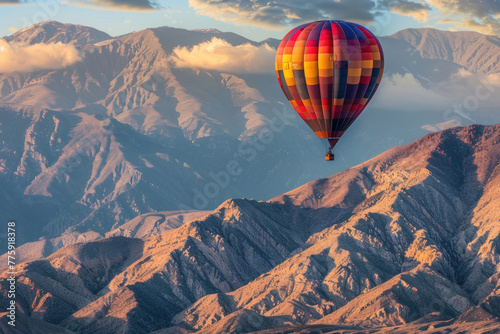 A creative and artistic photo of a hot air balloon flying over a mountain range