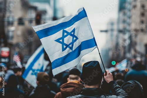 waving israeli flag in a crowd on street photo