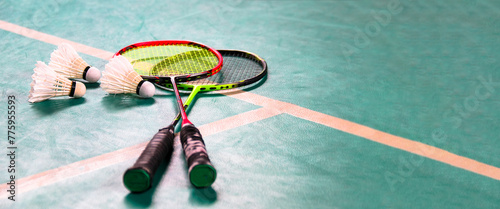 White badminton shuttlecocks and badminton rackets on green floor indoor badminton court soft and selective focus on shuttlecocks and the rackets