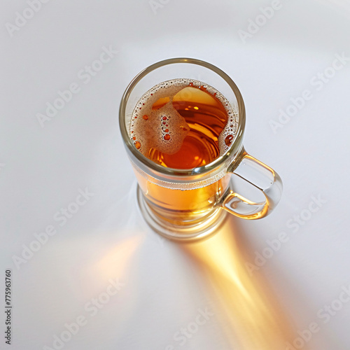 Top view of a full beer mug casting a long shadow, highlighting its golden color. photo