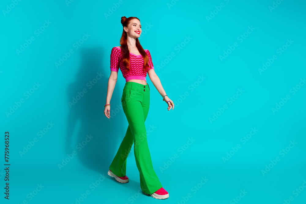 Full length photo of funky adorable lady dressed pink knitted shirt walking emtpy space isolated blue color background - obrazy, fototapety, plakaty 