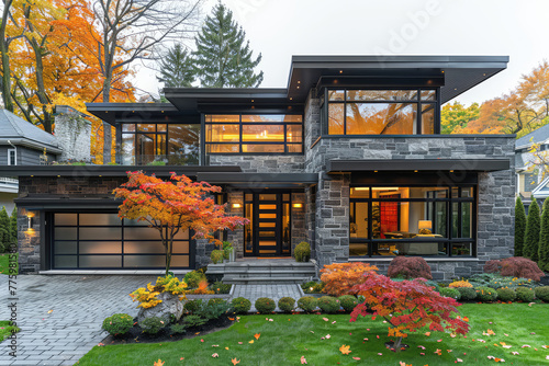 A modern, two-story house in the suburbs of Vancouver with stone and glass accents. The front yard features lush green grass and colorful autumn foliage trees. Created with AI photo