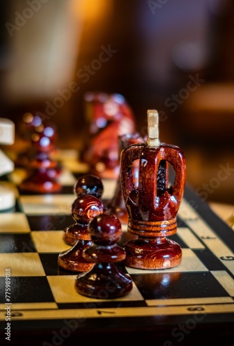 Closeup of a chess board with black figures, blurred background