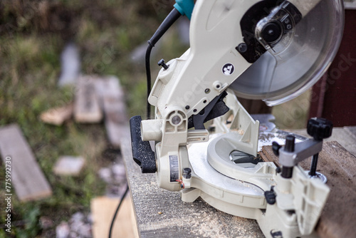 Close-up of mitre saw, cutting wooden boards outdoors.DIY concept