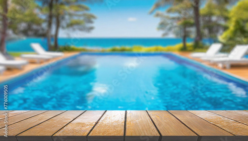 empty wooden table top and blurred swimming pool in tropical resort with blurred background.