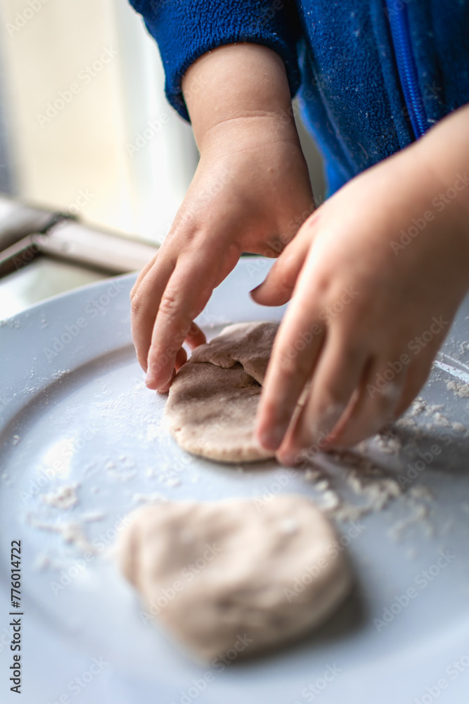 Fototapeta premium Child having fun modeling dough, authentic activity for fine motor skills development