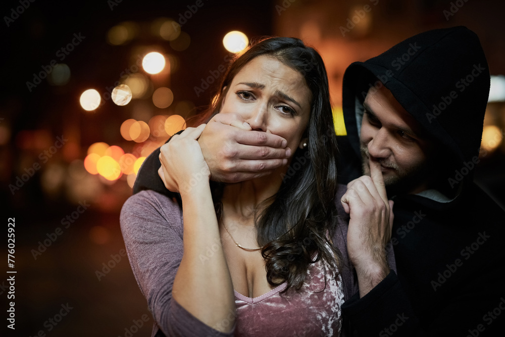 Woman, criminal and hand on mouth with fear for violence, danger and robbery in city at night with bokeh. People, portrait and silence emoji with terror, crime and stalker for kidnapping and hostage