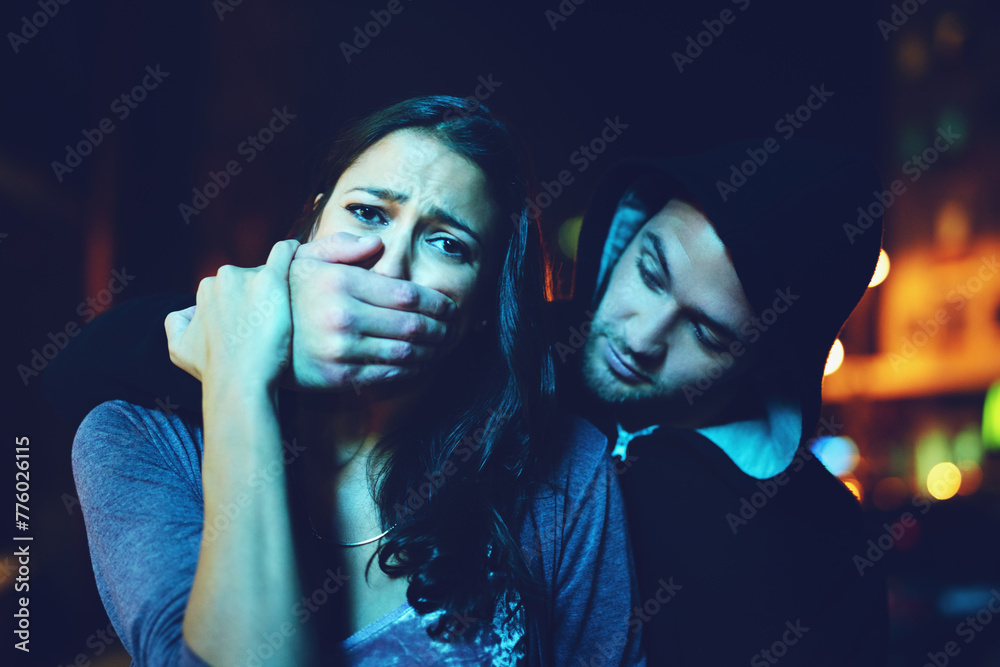 © peopleimages.com - Woman, criminal and hand on mouth with terror for violence, danger and robbery in city at night with bokeh. People, portrait and silence emoji with fear, crime and gangster for kidnapping and hostage