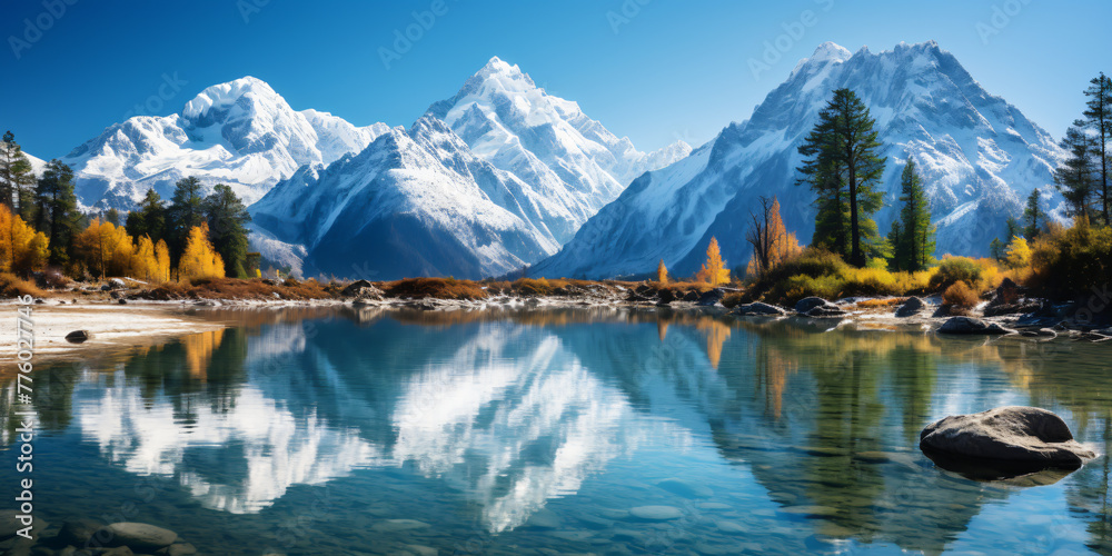 A clear blue river flows through a lush green valley surrounded by snow-capped mountains.