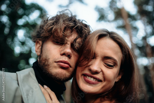 couple in love in the forest at sunset on a date hugging in a coat in the summer. Cinematic love story