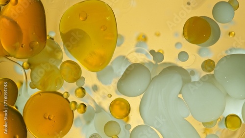 Freeze Motion Shot of Moving Oil and Milk Bubbles on Golden Background, Cosmetics Concept © Lukas Gojda