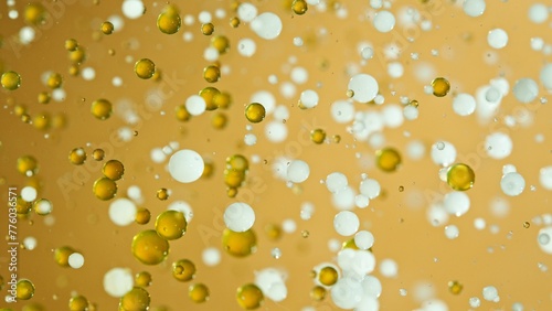 Freeze Motion Shot of Moving Oil and Milk Bubbles on Golden Background, Cosmetics Concept