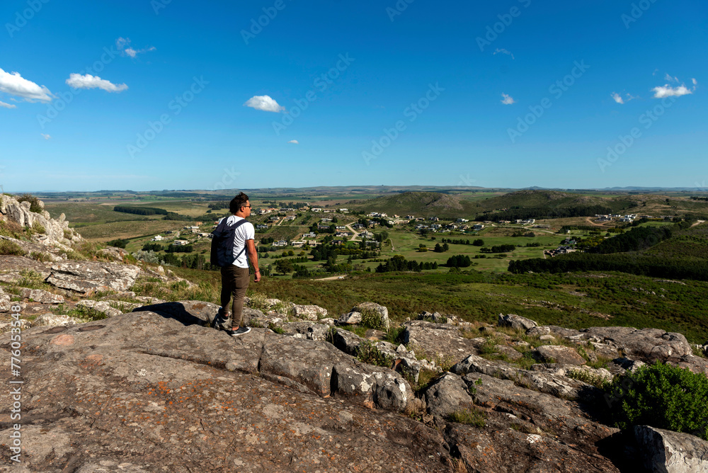 young traveling man in the mountains enjoying the great landscape between rocks and free vegetation observing 