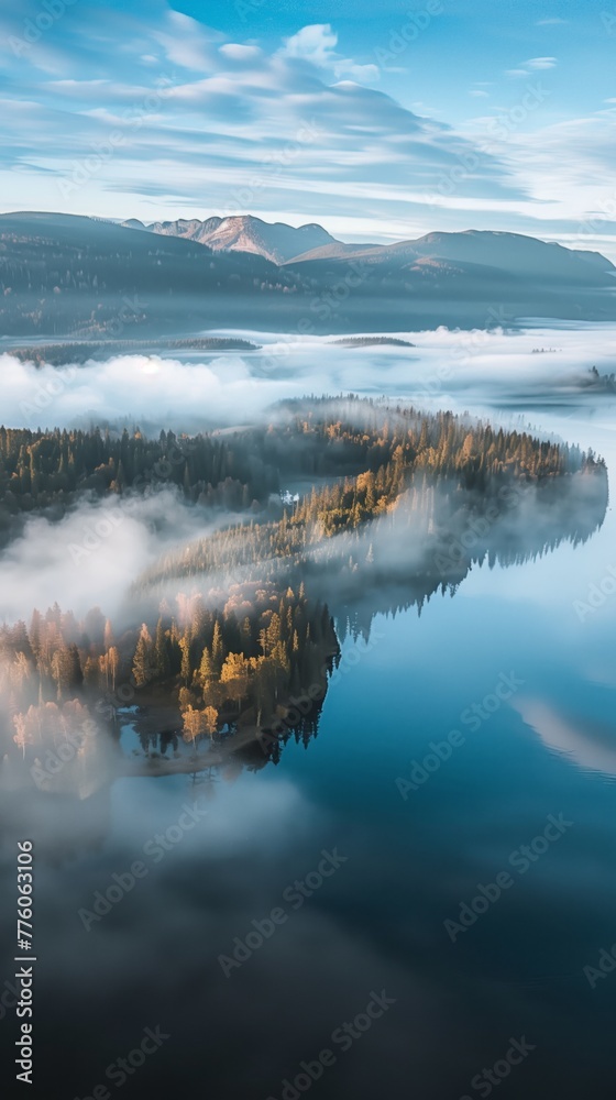 autumnal forest and mountains reflected in calm lake during sunrise