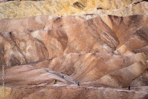 Hikers on the slopes of Zabriskie Point at sunrise in Death Valley National Park in California, United States