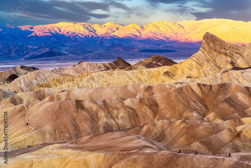 Hikers on the slopes of Zabriskie Point at sunrise in Death Valley National Park in California, United States