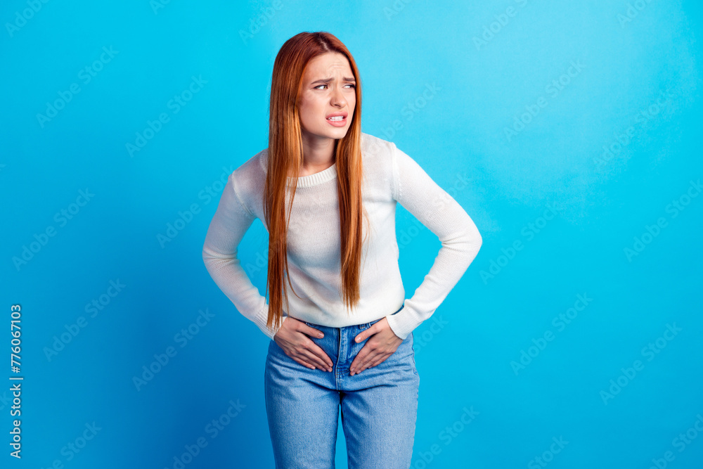 Photo portrait of attractive young woman suffer period cramps dressed stylish white clothes isolated on blue color background Photo portrait of attractive young woman suffer period cramps dressed stylish white clothes isolated on blue color background