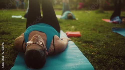 Close up senior woman doing workout activity with a group of friends in a public park - Health elderly people lifestyle