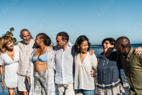 Happy multiracial senior friends having fun on the beach during summer holidays - Diverse elderly people enjoying vacations