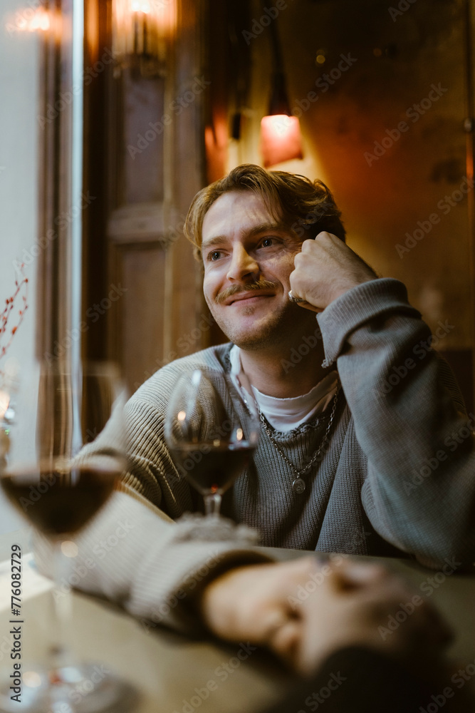 Smiling gay man on date with boyfriend at restaurant Smiling gay man on date with boyfriend at restaurant
