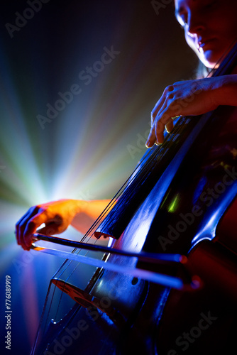 Εκτύπωση καμβά Close up portrait of talented young woman, musician, cellist performing symphony in purple-blue spotlights on stage with smoke