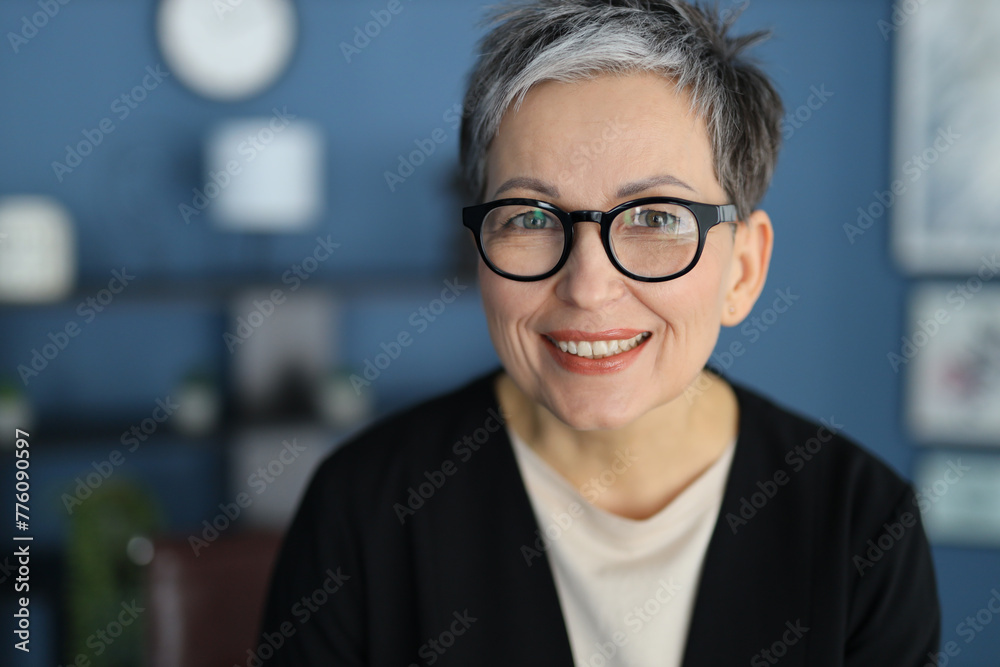 A mature Caucasian woman smiles confidently in a portrait, embodying happiness and successful aging. A mature Caucasian woman smiles confidently in a portrait, embodying happiness and successful aging.