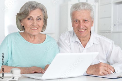 portrait of two old people working with a laptop in the office