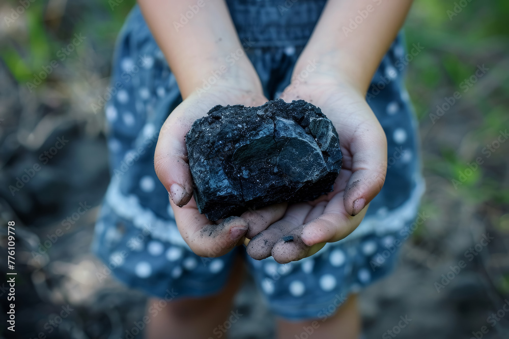Child's Hand Grasping Coal Lump