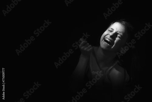 Conceptual image: lost childhood, emotional pain, and children's pain, depression and domestic violence. Portrait of sad and desperate young girl crying. Copy space.