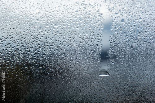 Image of cold tones of water droplets condensed on a glass