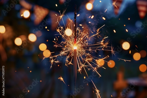 single burning sparkler with 4th of july party with US flags in the background