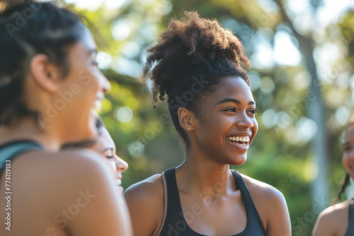 A group of friends laughing and bonding during a outdoor fitness class in the park, surrounded by greenery and fresh air