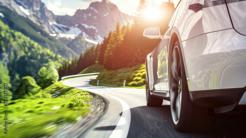 close-up of a modern car driving fast along a serpentine road in the mountains in the rays of the sun