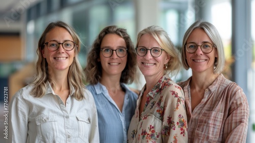 Five female colleagues at a work meeting smiling to camera