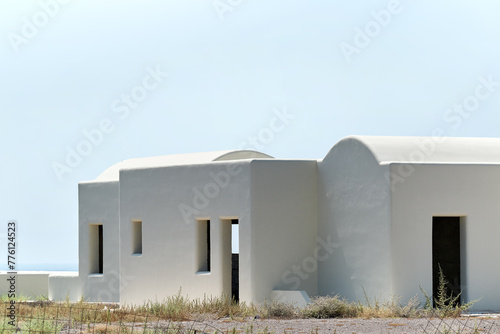 Traditional white house under construction with blue sky as background in Santorini, Greece
