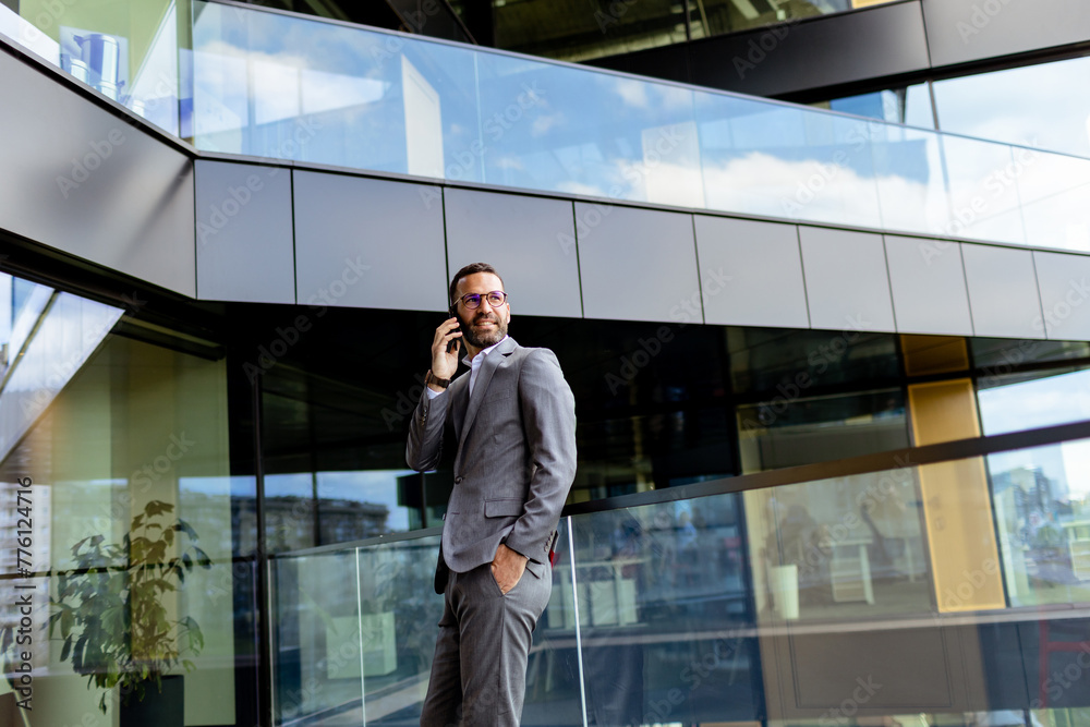 Confident Businessman Smiling in Sharp Suit Against Modern Glass Office Facade Confident Businessman Smiling in Sharp Suit Against Modern Glass Office Facade