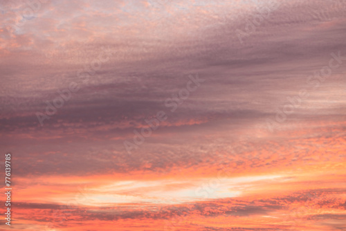 A beautiful sky tinted by the sun leaving vibrant shades of gold, pink, blue and multicolored. Clouds in the twilight evening and morning sky. Cloudy sky background in the evening and during the day.