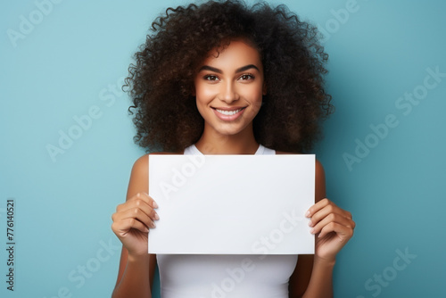 smiling woman holding a blank card, blue background, space for text, mock up photo