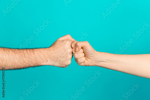 Photo of two people arms palms bumping fists showing confrontation isolated teal color background